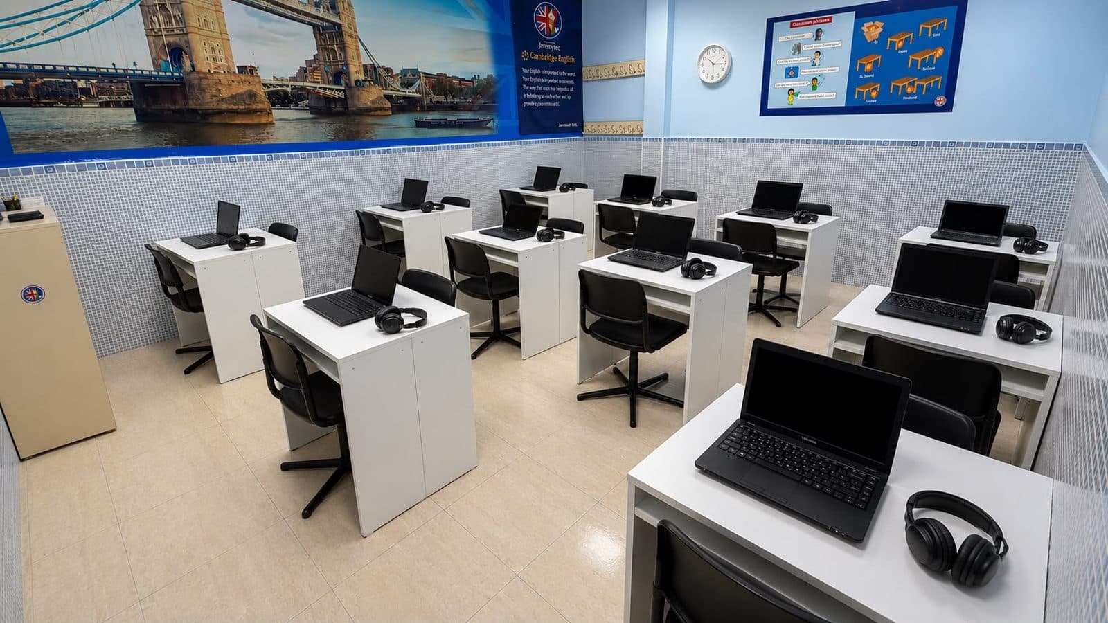 El aula de ordenadores de la academia, con un portátil y auriculares en cada mesa